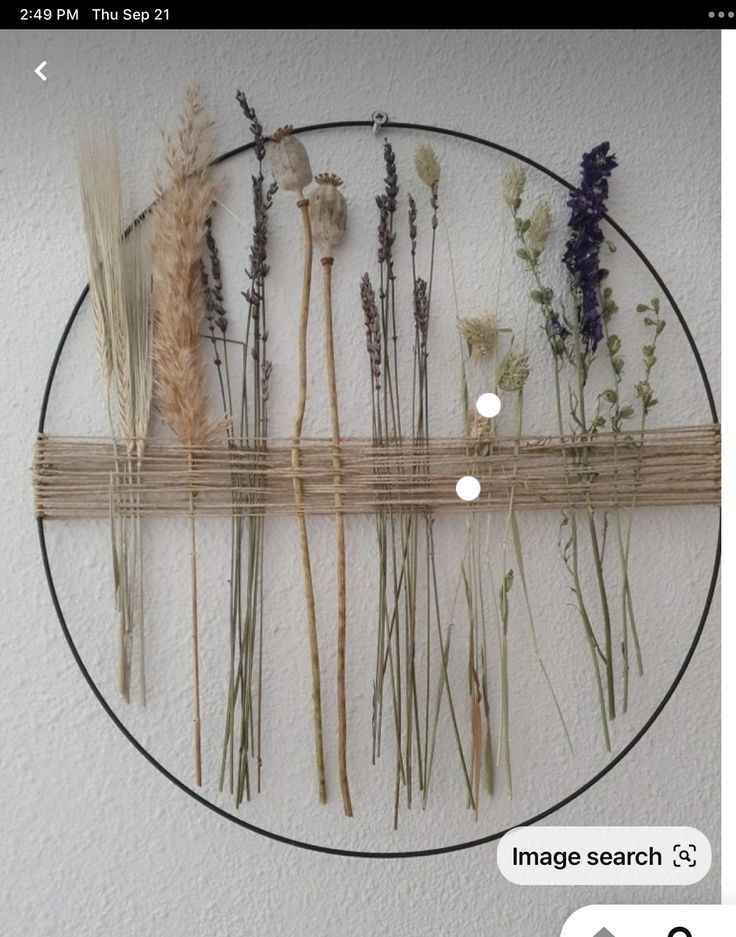 an image of dried flowers arranged on a circular wall hanging frame with text below it