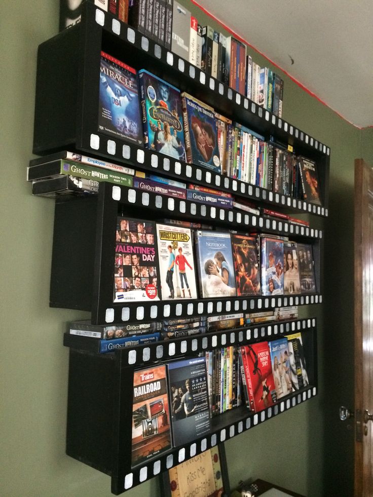 a wall mounted movie shelf with movies on it and other movies hanging from the shelves