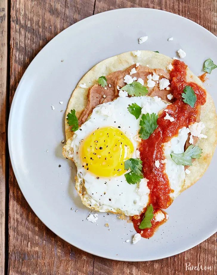 an egg is sitting on top of a flatbread with sauce and parmesan