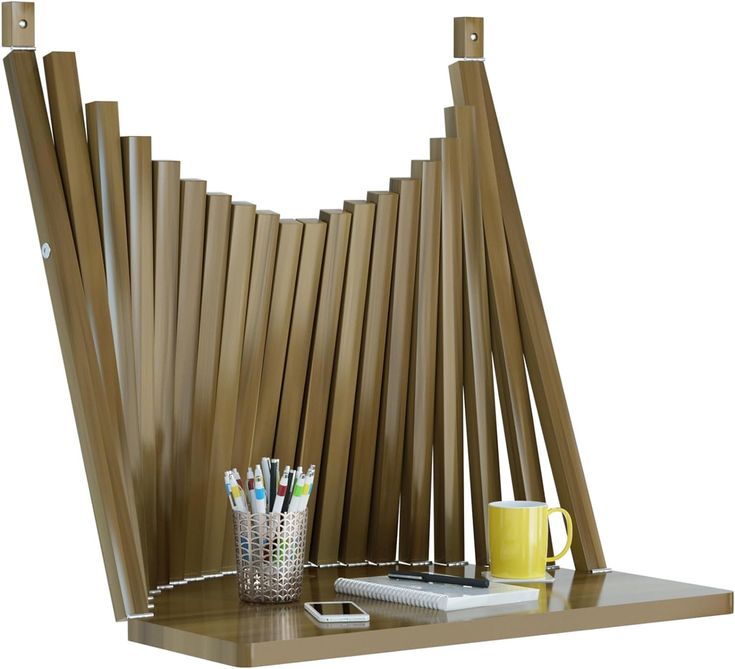 a wooden shelf with some pens, pencils and a cup on top of it