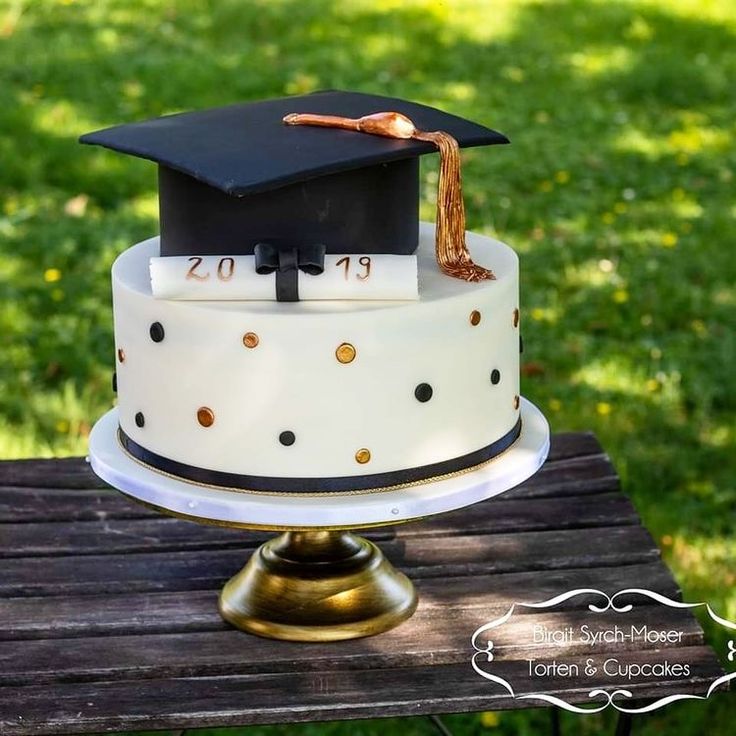 a graduation cake sitting on top of a wooden table