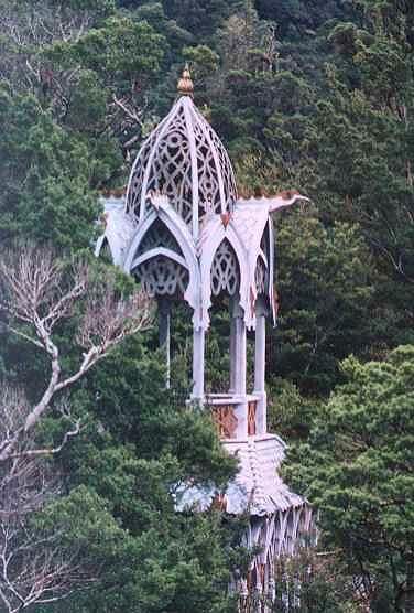 an ornate building surrounded by trees in the woods