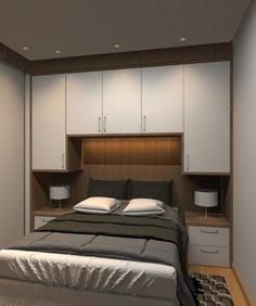 a bed sitting in a bedroom next to white cupboards