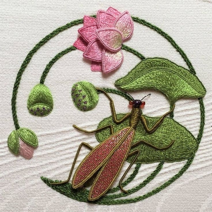 a close up of a piece of cloth with flowers and bugs in the middle on it