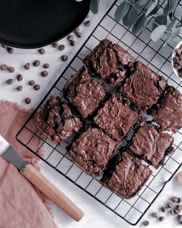 chocolate brownies on a cooling rack next to coffee beans