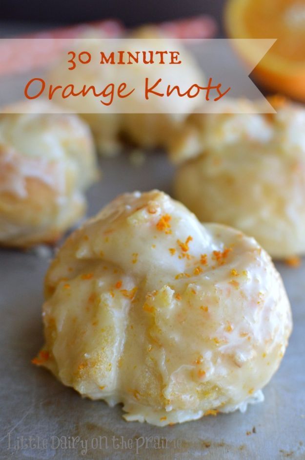 orange cookies with icing and sprinkles on a baking sheet next to an orange