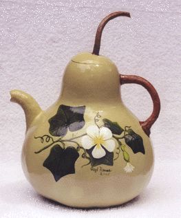 a ceramic tea pot with flowers painted on it