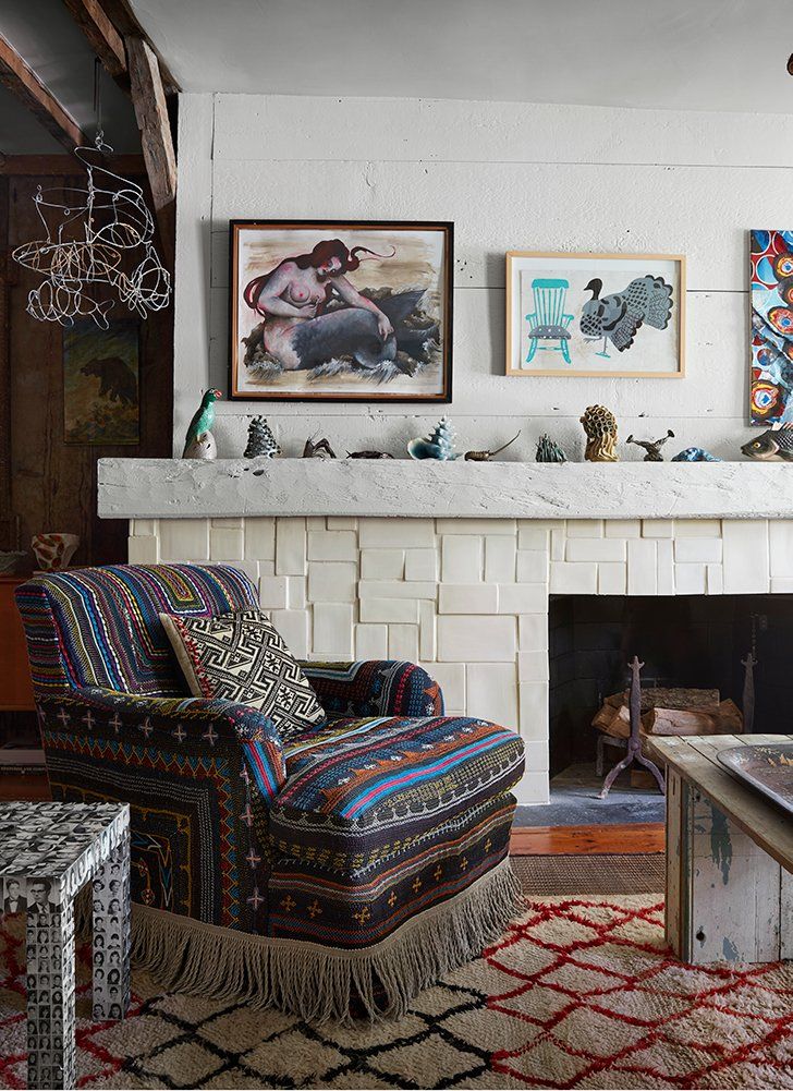 a living room filled with furniture and a fire place under a painting on the wall