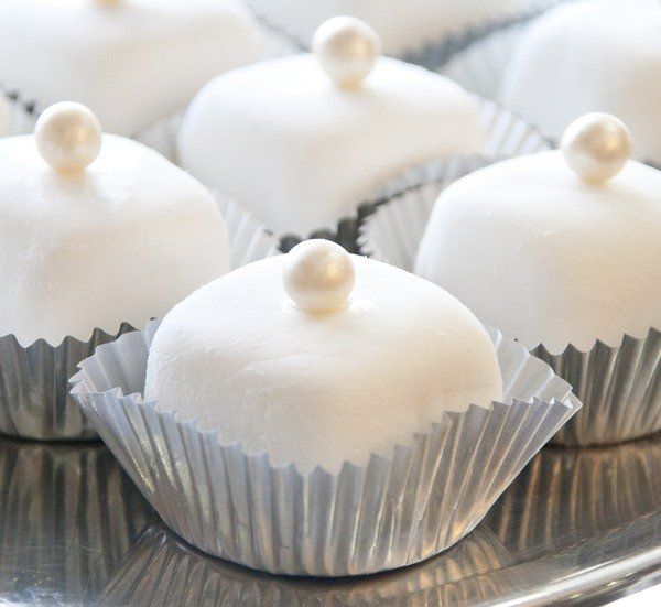 some white desserts are sitting on a silver tray