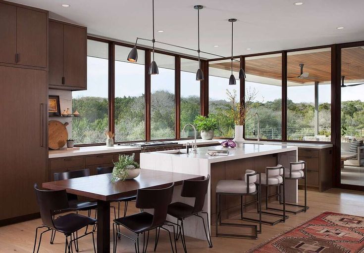 a large kitchen with an island in the middle and lots of windows on both sides