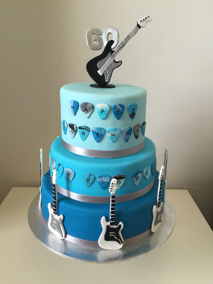 a blue and silver cake with guitars on it