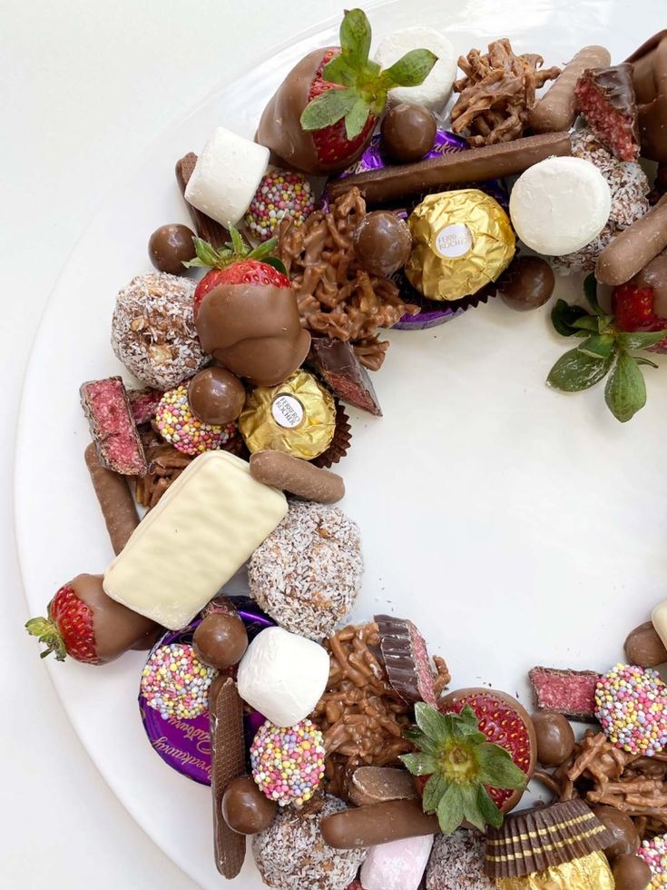 a white plate topped with chocolate covered strawberries and marshmallows