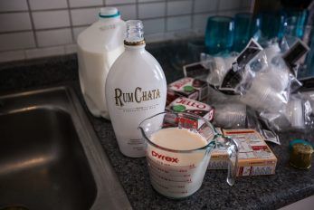 a kitchen counter with milk, sugar and other items on it next to a sink