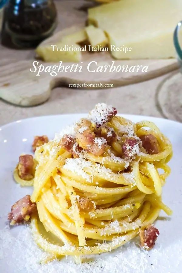 spaghetti carbonara with bacon and parmesan cheese on a white plate, ready to be eaten