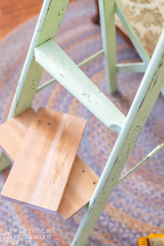 a wooden step stool sitting on top of a rug