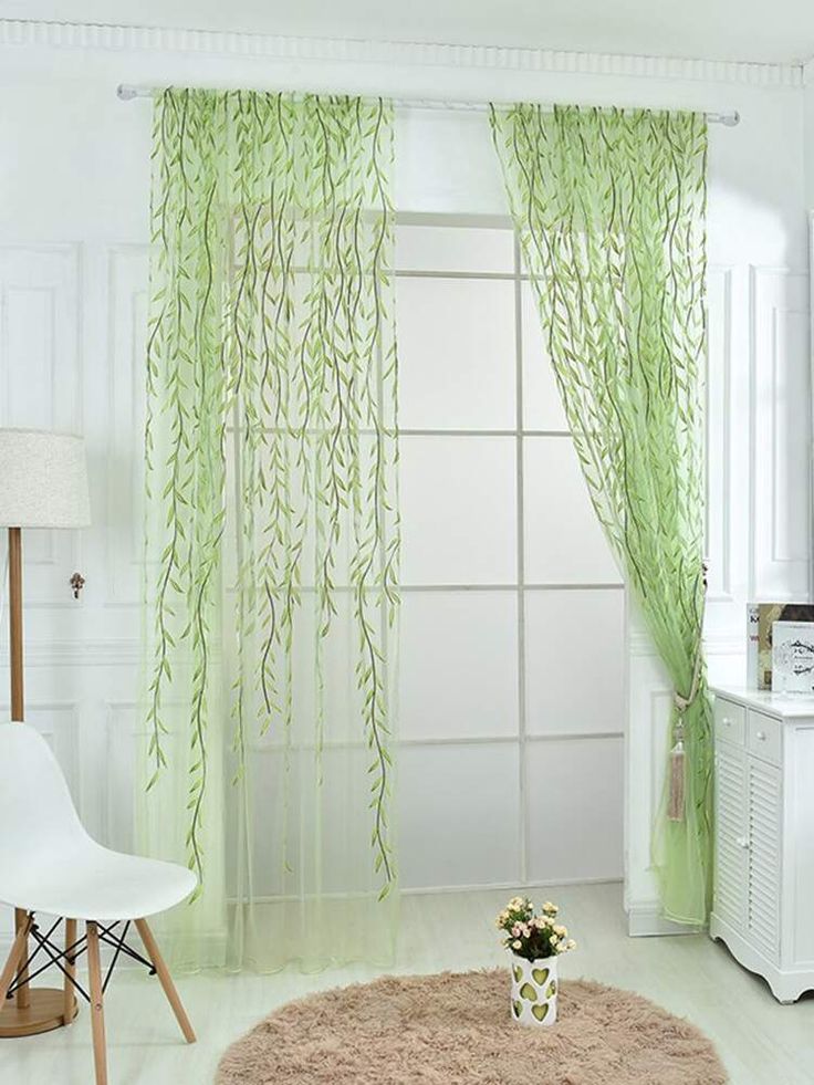 a living room with white furniture and green curtains