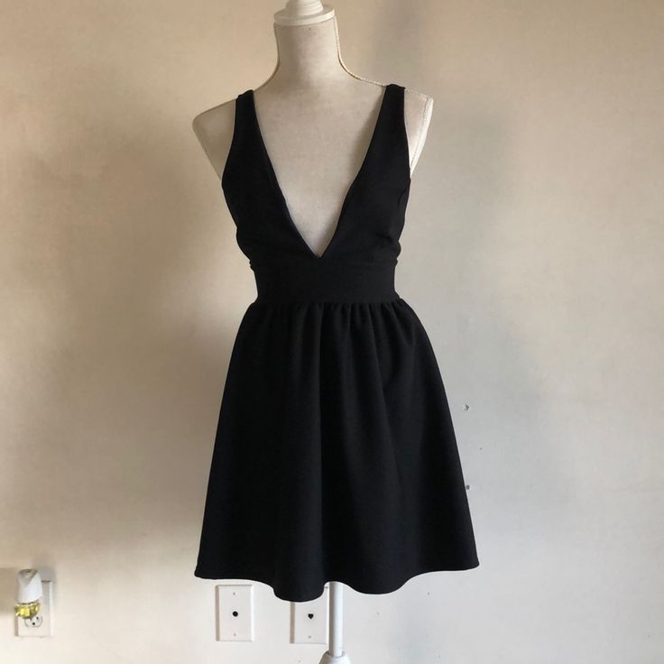 Plunging Neckline Black Dress. Never Worn, Great Condition. 32” Length Chic Lined Backless Dress For Night Out, Chic V-neck Backless Dress For Day Out, Chic Black Backless Dress For Day Out, Elegant Black Backless Dress For Day Out, Backless Lined Mini Dress For Date Night, Black Backless Dress For Day Out, Chic V-neck Backless Dress For Cocktail, Chic V-neck Backless Dress For Going Out, Chic Backless V-neck Dress For Going Out