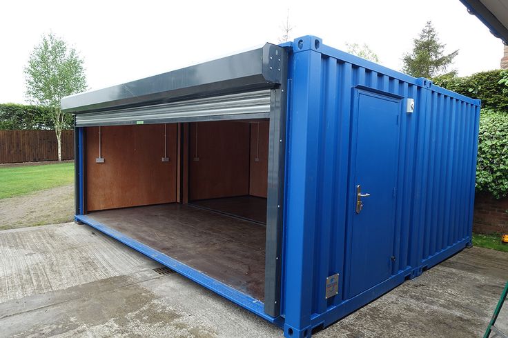 a large blue shipping container sitting on top of a cement floor next to a fence