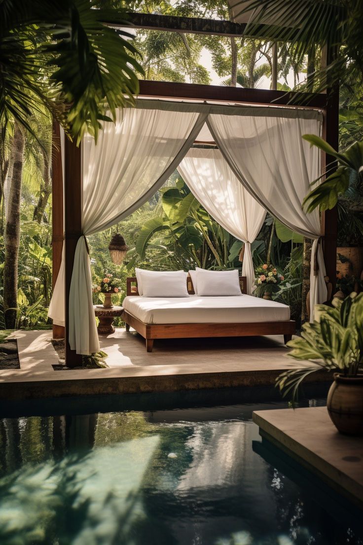 a bed sitting in the middle of a lush green forest next to a swimming pool