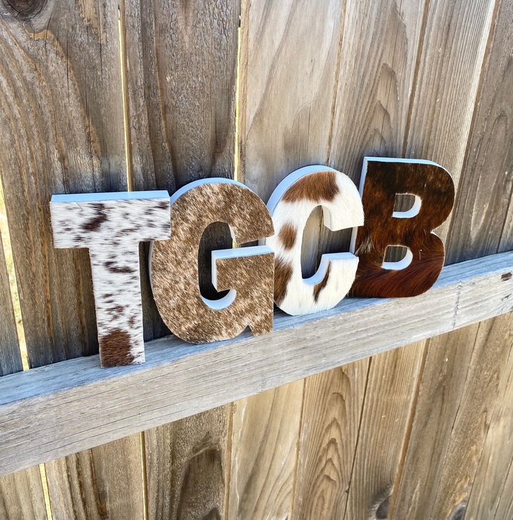 the letters are made out of cowhides and wood, along with some other animal print