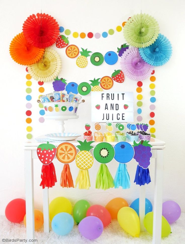 a fruit and juice themed birthday party with balloons, tassels, paper fan decorations