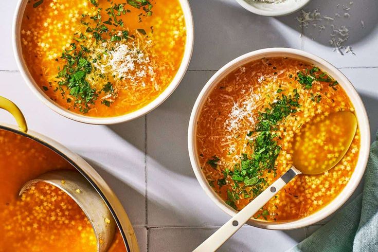 three bowls filled with soup on top of a table