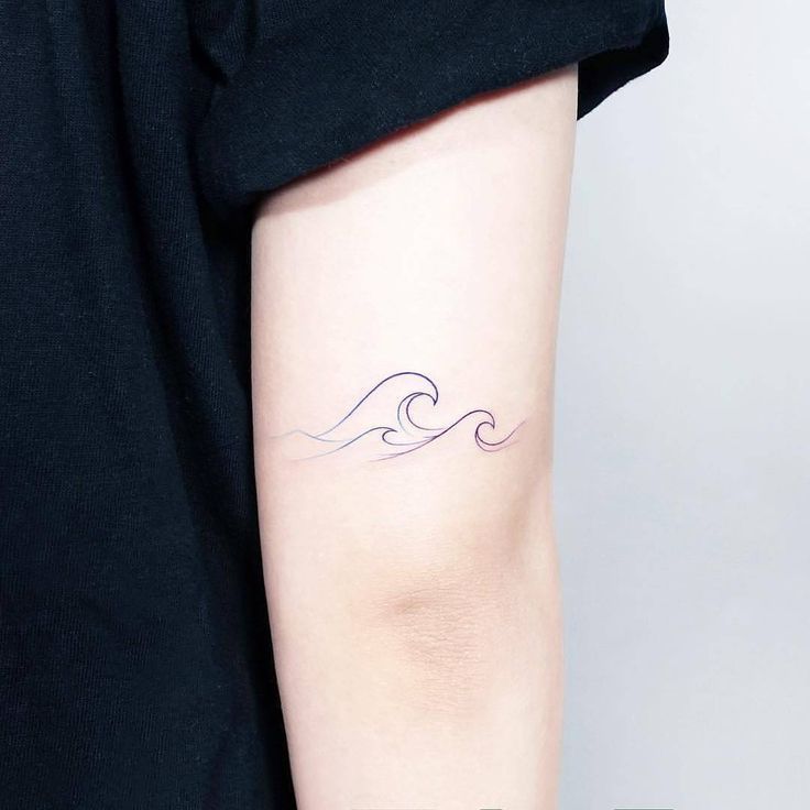 a woman's arm with a wave tattoo on the left side of her arm