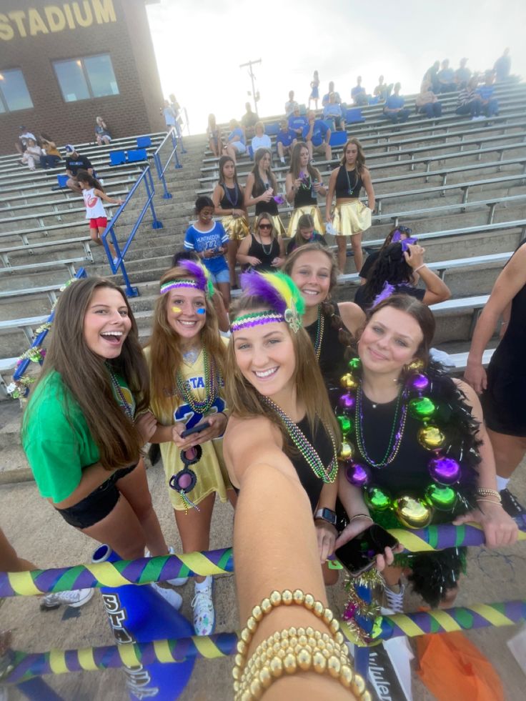 a group of young women standing next to each other in front of bleachers