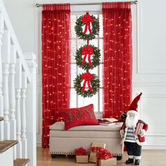 a living room decorated for christmas with red curtains and presents on the floor next to santa clause