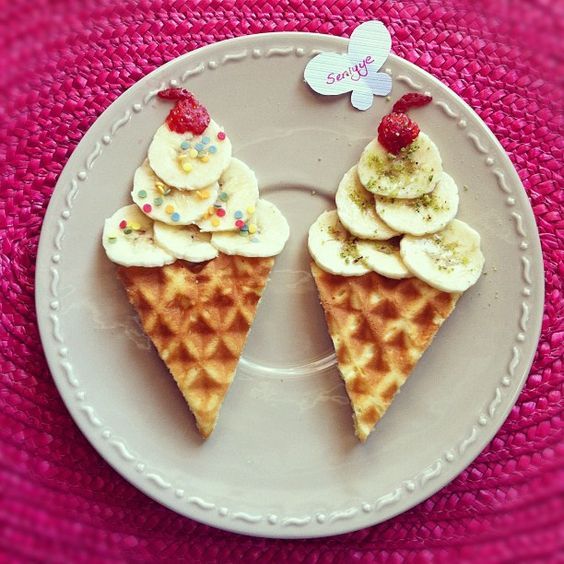 two waffles with banana slices and strawberries on them are sitting on a plate