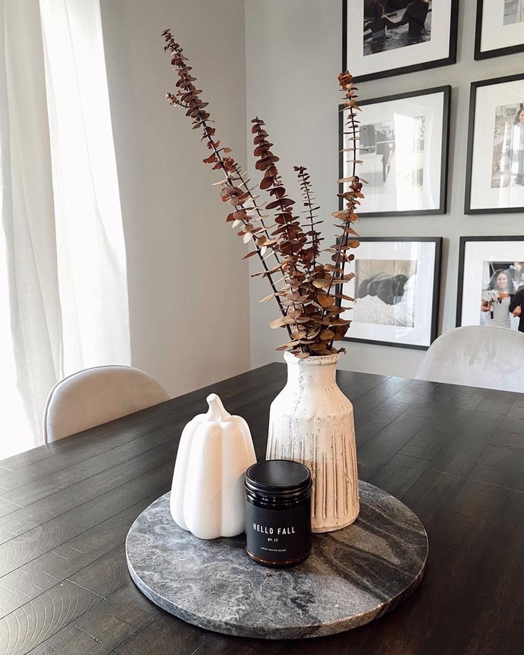 there is a vase with some flowers in it on the table next to two candles