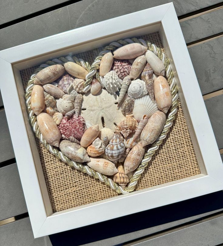 a heart made out of seashells in a frame