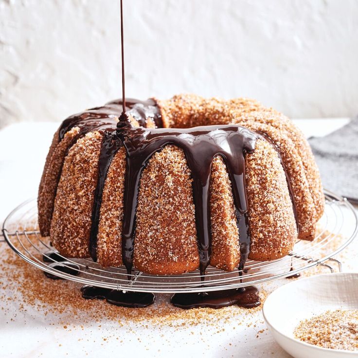 a bundt cake with chocolate icing and sprinkles on a wire rack