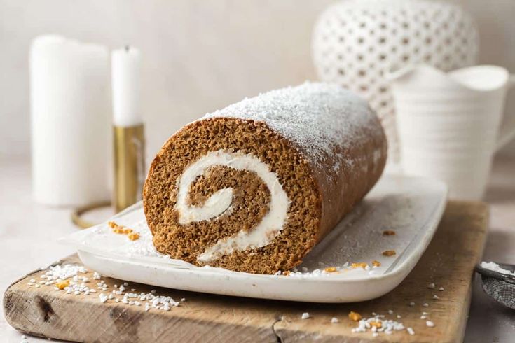 a cinnamon roll on a plate with powdered sugar