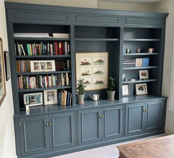 a living room with bookshelves and pictures on the wall