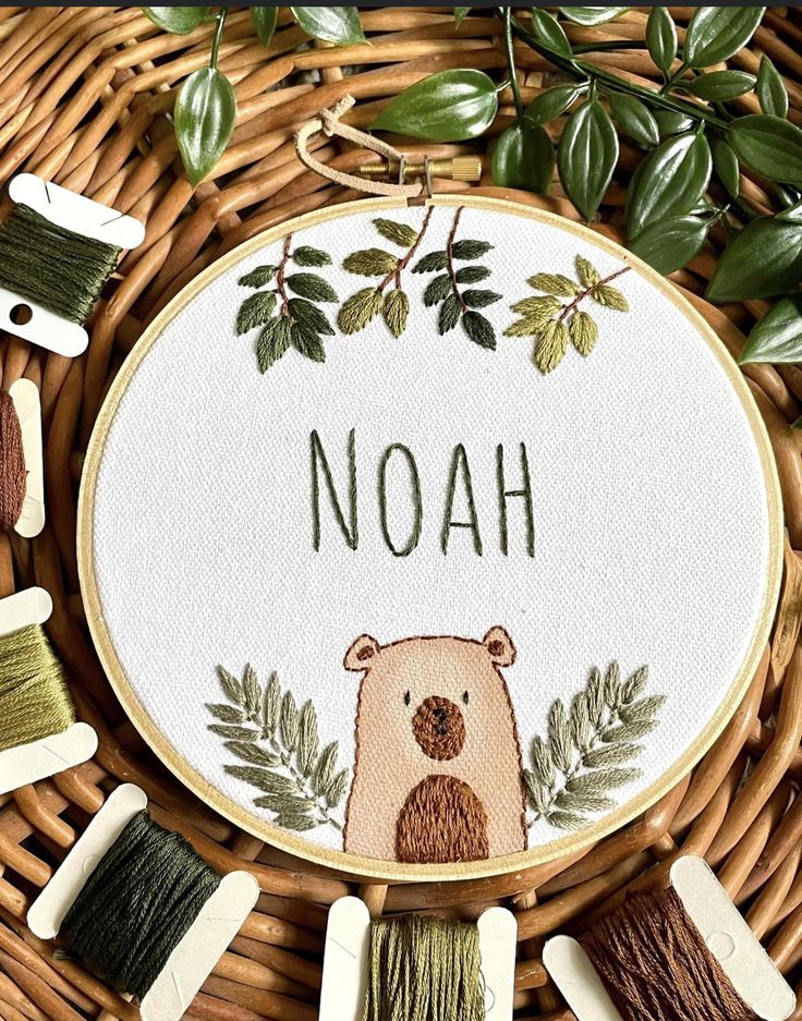 a cross stitch pattern with the word noah written on it in front of several different colored thread spools