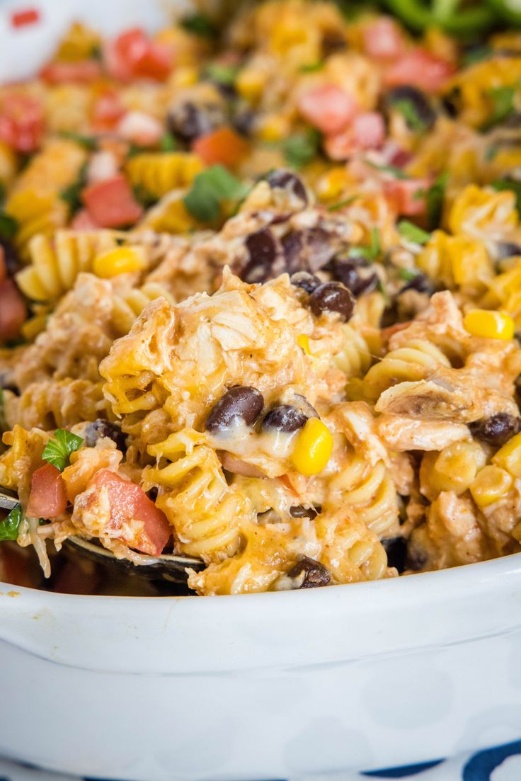 a casserole dish filled with pasta, beans and veggies in a white bowl