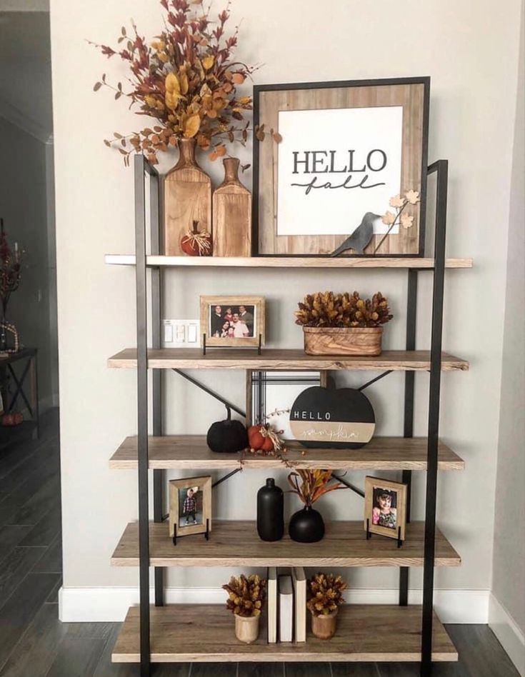 a shelf with pictures, vases and other items on it in a living room