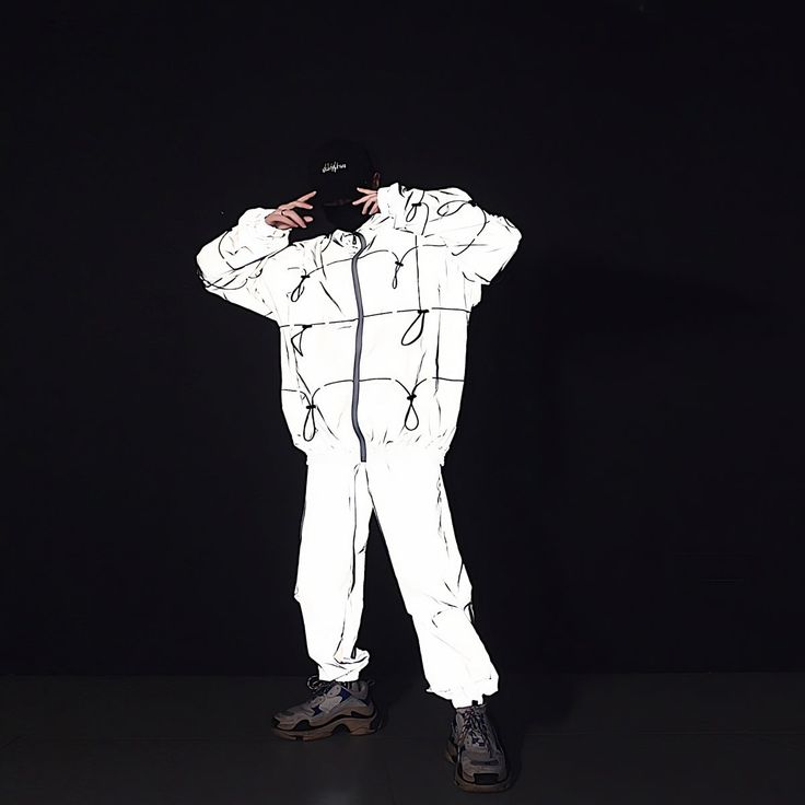 Our Reflective Techwear Jacket is low-key until you don't want it to be. The Techwear Jacket is in a smooth grey, but when it reflects any kind of light, it comes to life in a bright color mix between silver and white. It looks like it is from another dimension. Perfect for your next Festival, Rave, or Night Out Fitted White Reflective Winter Outerwear, Sporty White Track Jacket With Reflective Details, Casual Long Sleeve Outerwear With Reflective Logo, Winter White Outerwear With Reflective Details, White Hooded Windbreaker With Reflective Details, White Sporty Windbreaker With Reflective Details, White Reflective Long Sleeve Windbreaker, White Windbreaker For Winter Streetwear, White Techwear Outerwear For Streetwear