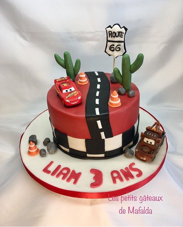 a birthday cake with cars on the side