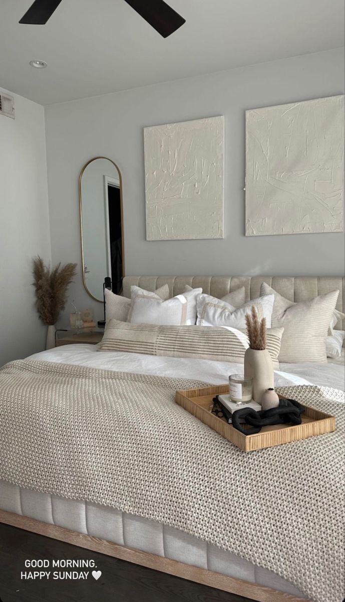 a bed with white linens and pillows in a small room next to a mirror