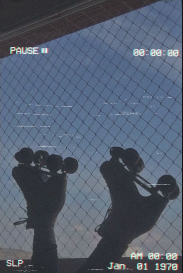 the reflection of someone's feet and skateboard in front of a fence