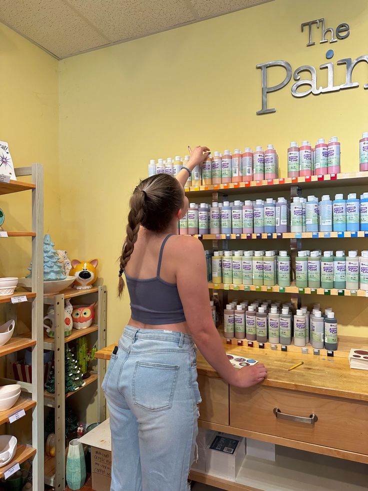 a woman is standing in front of the pain counter