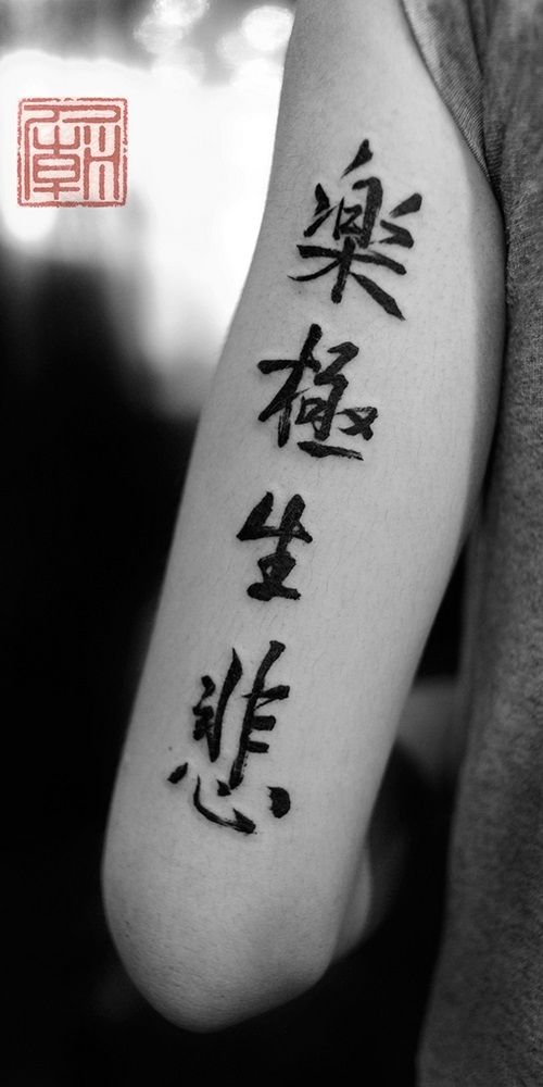 a person with a tattoo on their arm that has chinese characters written in black ink