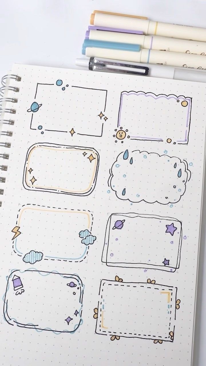 an open notebook with stickers on it and some pens sitting next to the pages