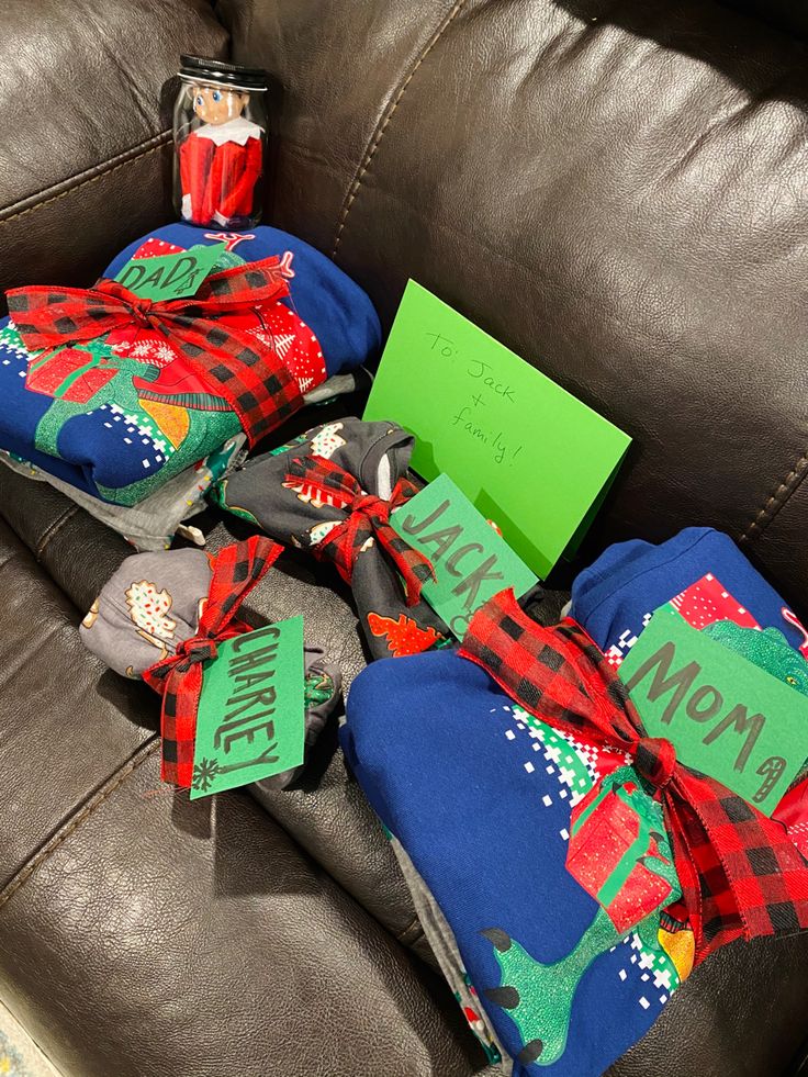 a pile of christmas presents sitting on top of a brown leather couch next to a green sign