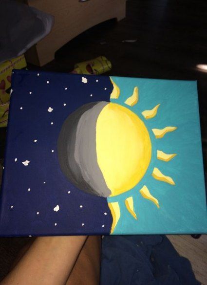 a painting of the sun and moon is being held up by someone's hand