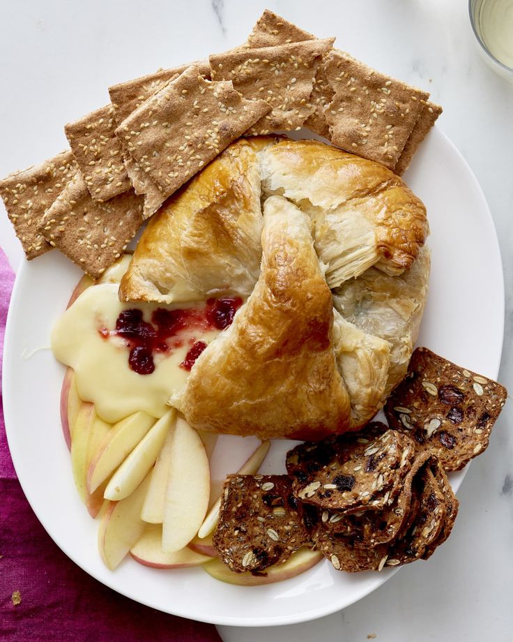 a white plate topped with fruit and crackers