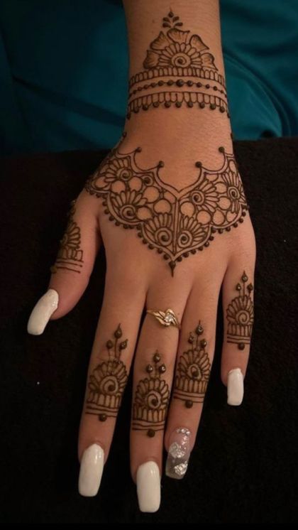 a woman's hand with henna tattoos on it