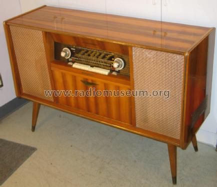 an old fashioned radio sitting on top of a wooden cabinet